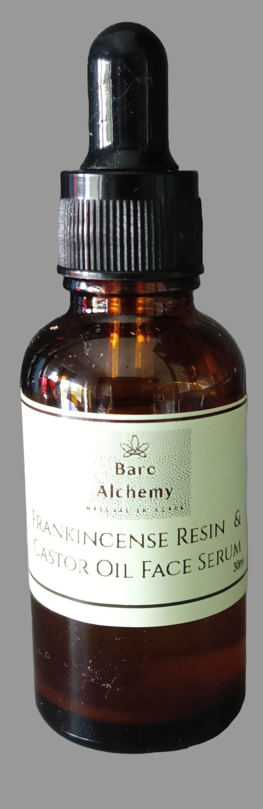 Bottle of frankincense resin and castor oil face serum on light grey background
