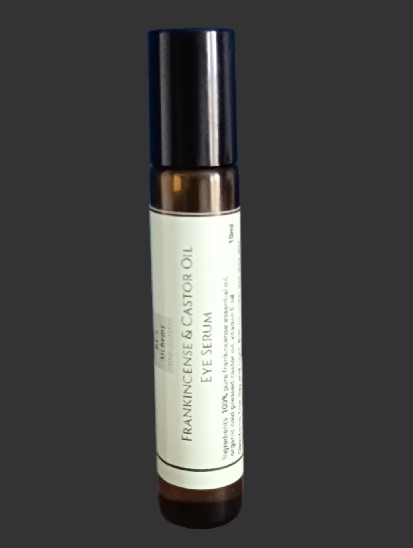 frankincense and castor oil eye serum in roller bottle on grey background
