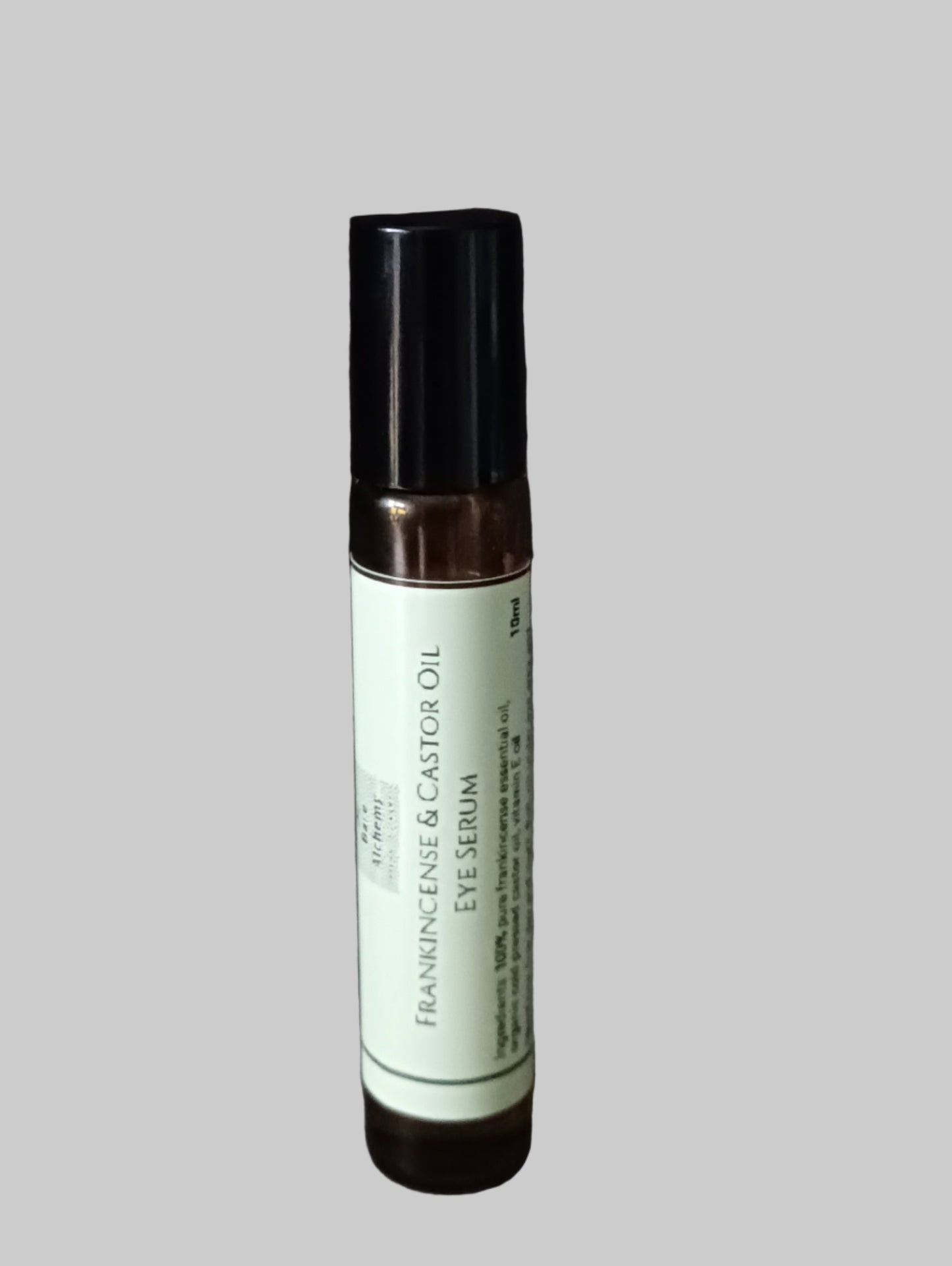Skincare serum bottle with black cap and white label on a gray background