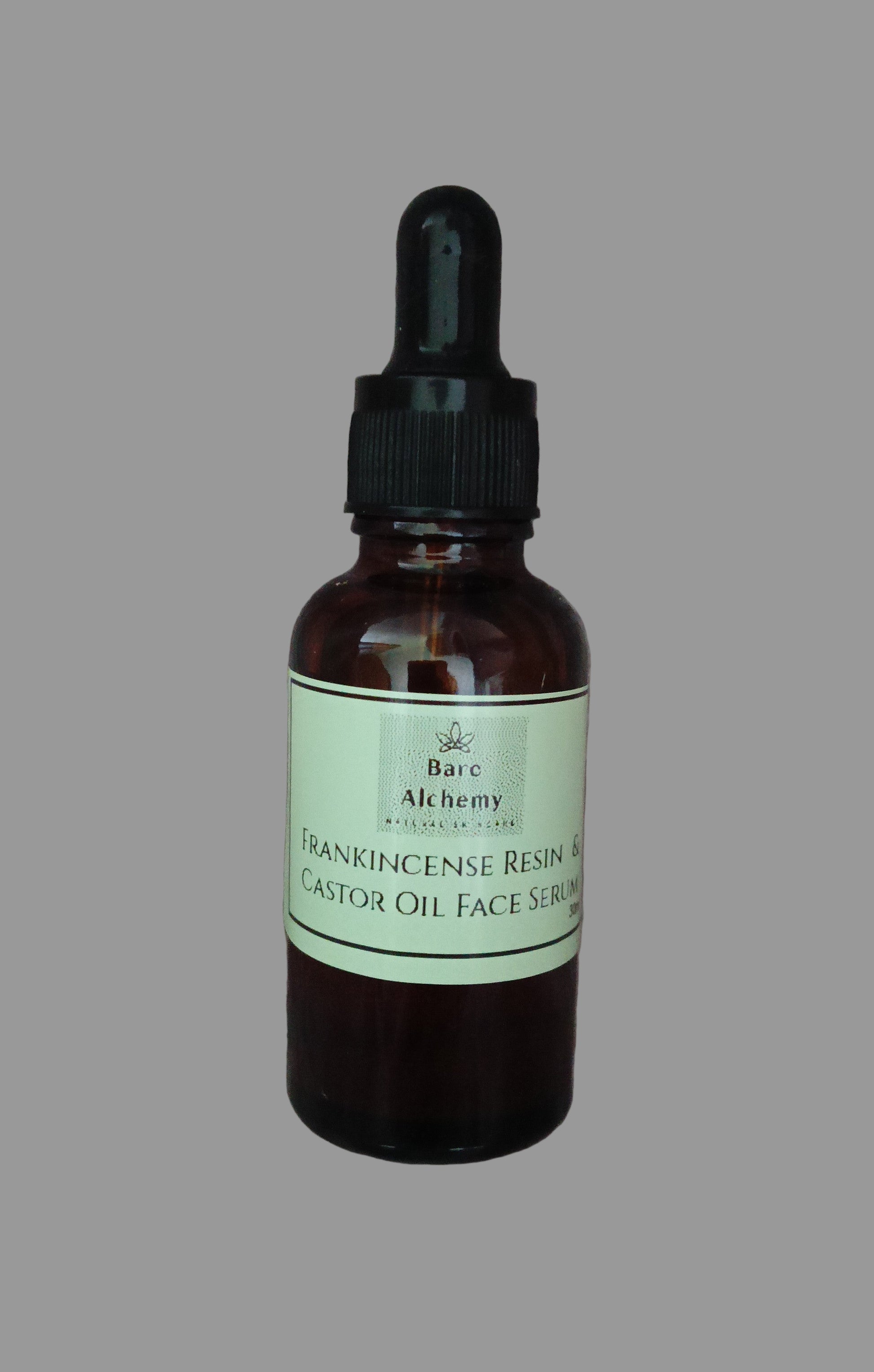 Bottle of Frankincense Resin & Castor Oil Face Serum with dropper on a textured gray background