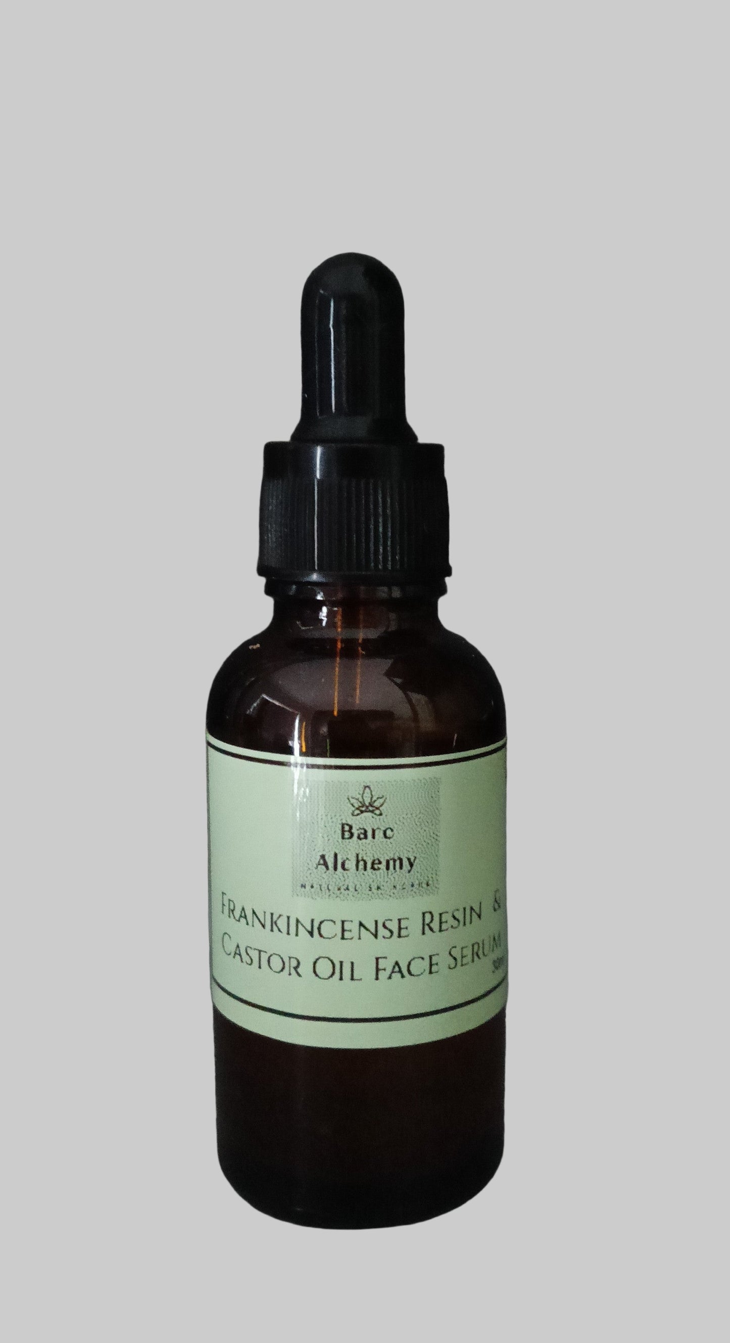 Bottle of Frankincense Resin & Castor Oil Face Serum with a dropper on a gray background